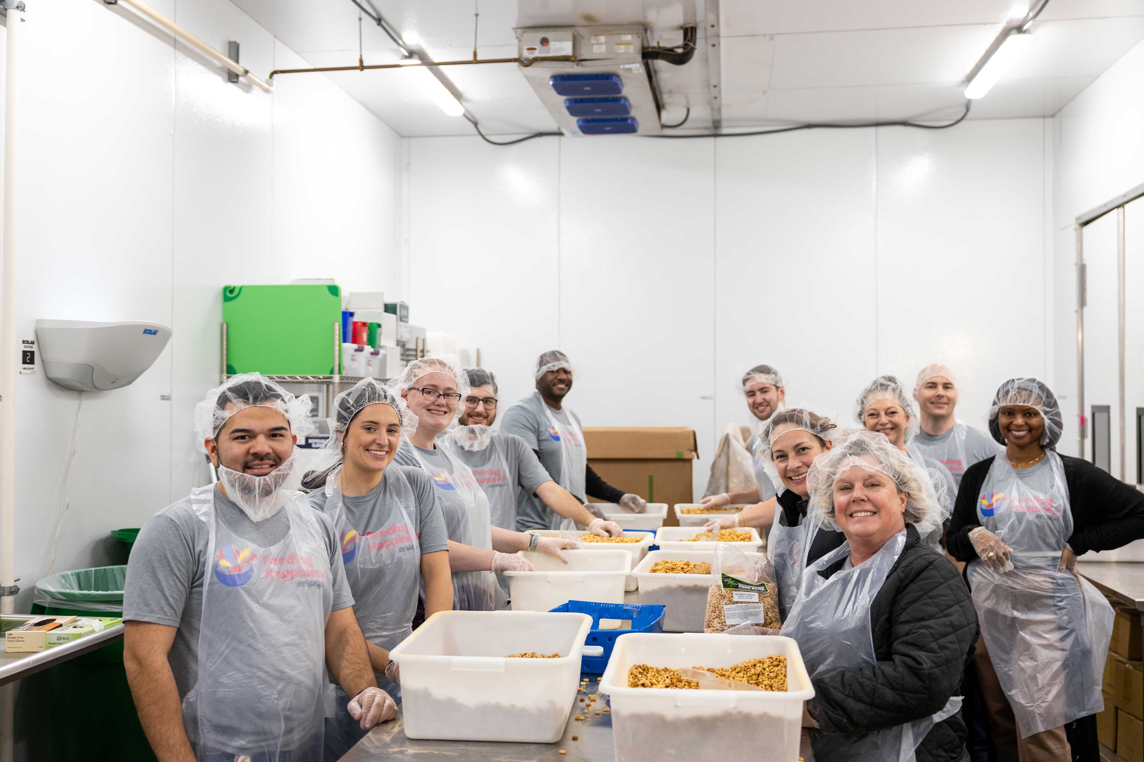 Kellogg employees volunteering to prepare food and smiling